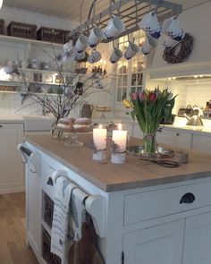 a kitchen filled with lots of counter top space and candles on the island in front of it