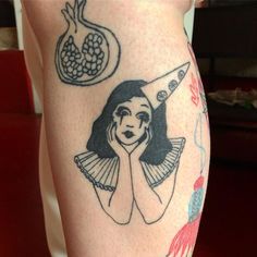 a woman's leg with tattoos on it and an image of a knife in the background