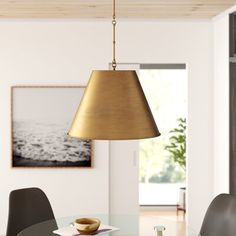 a dining room table with two chairs and a light fixture hanging from it's ceiling