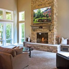 a living room with two couches and a fire place in the middle of it