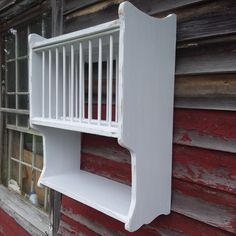 a white shelf sitting on the side of a red building