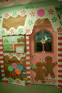 a gingerbread house decorated with candy canes and candies on the front door