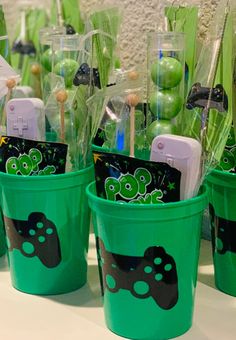 some green cups with candy sticks in them