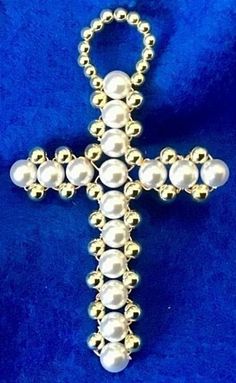 a cross made out of beads on a blue background