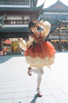 a woman in a red and white dress holding a lantern