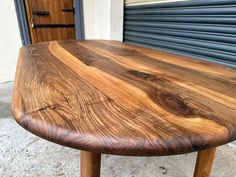 a wooden table sitting on top of a sidewalk