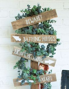 a wooden sign that says beware, bathing hippos and lion crossing