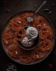 an overhead view of food on a plate with utensils and nuts in the background