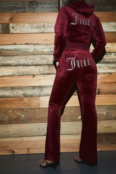 a woman in a red velvet jumpsuit with the word june printed on it's back