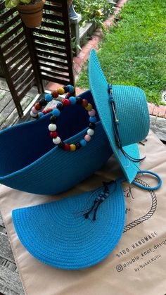 two hats sitting on top of a table next to a bag with beads and tassels