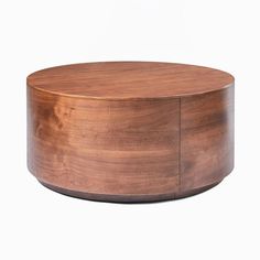 a round wooden table sitting on top of a white floor