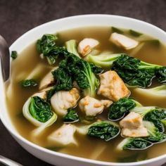 a white bowl filled with chicken and spinach soup