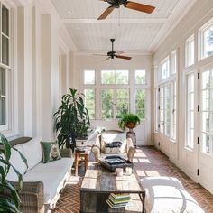 the sun shines through the windows in this living room with white walls and brick flooring