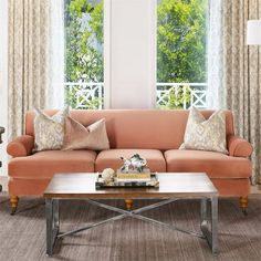 a living room with two couches and a coffee table in front of the window