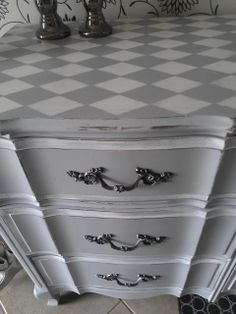 a white and grey dresser with two silver faucets on it's sides