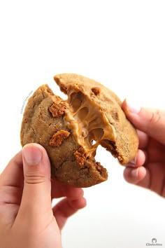 a person holding a half eaten cookie with peanut butter on it's crusts