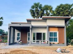 a small house with palm trees in the back ground and dirt on the ground next to it