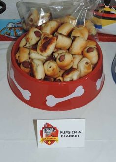 a red bowl filled with pigs in a blanket