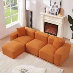 an orange sectional sofa sitting on top of a white rug in front of a fireplace