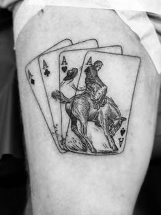 black and white photo of a man's leg with playing cards on his thigh