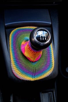 the interior of a car with a multicolored steering wheel cover and a button