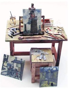 an easel with art supplies and paintings on it