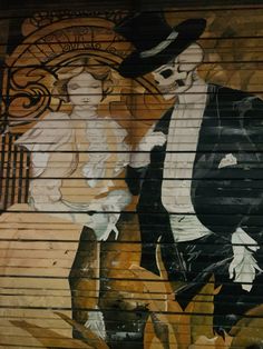 a painting on the side of a building with a man and woman dressed in black