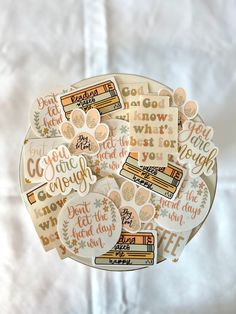 some stickers that are sitting on top of a white plate with words in it