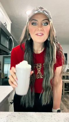 a woman with long hair is holding a cup