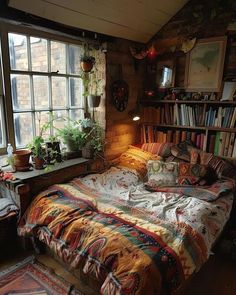 a bed sitting in front of a window next to a book shelf filled with books