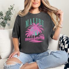 Malibu retro tshirt, Malibu california, palm trees, ocean vibes, retro trendy tee, boardwalk, summer vibes, comfort colors *Size up* for an OVERSIZED FIT (see size chart in listing photos). COMFORT COLORS Garment-dyed t-shirt, made 100% with ring-spun cotton. The soft-washed, garment-dyed fabric brings extra coziness to your wardrobe while the relaxed fit makes it an excellent daily choice. The double-needle stitching throughout the tee makes it highly durable while the lack of side-seams helps Trendy T-shirt With Front Print For Vacation, Casual Palm Tree Print Tops For Surfing, Graphic Tee With Tropical Print For Vacation, Relaxed Fit Graphic Tee With Tropical Print, Trendy Beach T-shirt, Trendy Graphic Print T-shirt For Vacation, Trendy Front Print T-shirt For The Beach, Casual Relaxed Fit T-shirt With Tropical Print, Casual Tropical Print T-shirt For Vacation