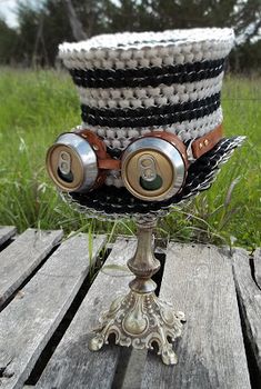 a top hat with eye glasses on it sitting on a wooden table in the grass