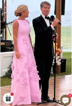 a man in a tuxedo standing next to a woman in a pink dress