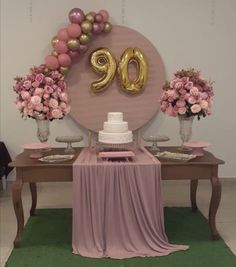 a table topped with a cake and balloons