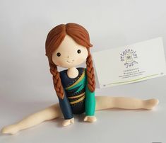 a small doll sitting next to a business card