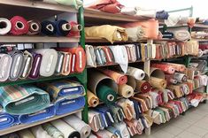 many different types of fabrics on shelves in a store