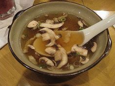 a bowl filled with soup sitting on top of a wooden table