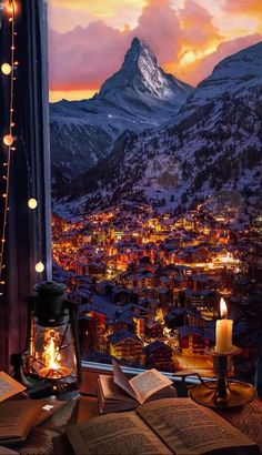 an open book sitting on top of a window sill next to a lit candle