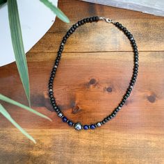 This men's necklace is hand beaded with stained wood, Lapis Lazuli and Hematite beads, with one large Hematite bead in the center. ~As a healing stone Lapis Lazuli has a strong connection with the throat chakra. It encourages self-awareness, allows self-expression and reveals inner truth, providing qualities of honesty, compassion and morality to the personality. Lapis Lazuli assists to confront and speak one's truth and inspires confidence. ~Hematite helps to absorb negative energy and calms in times of stress or worry. Hematite is a very protective stone and is great to help you stay grounded in many situations. It is said to be effective in healing pain because it maintains the charge of nerve cells and is often worn to help with arthritis.  These two gemstones work harmoniously togethe Handmade Hematite Bead Necklaces, Blue Beaded Hematite Jewelry, Hematite Natural Stones Necklace For Gift, Elegant Beaded Hematite Necklace, Adjustable Hematite Beaded Necklace, Lapis Necklace, Hematite Necklace, Earthy Jewelry, Lapis Lazuli Necklace