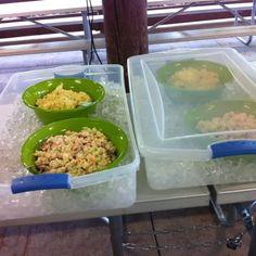 three plastic containers filled with food sitting on top of a white table covered in ice