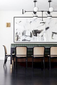 the dining room table and chairs are in front of a large painting on the wall