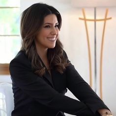 a woman sitting at a table smiling for the camera