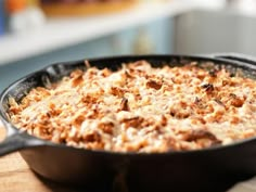 a skillet filled with food sitting on top of a wooden table