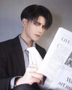 a man with black hair reading a newspaper