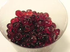 a glass bowl filled with red and black berries