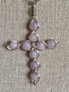 a silver cross with pink stones on it