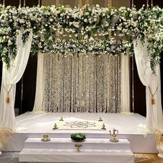 a wedding ceremony setup with white flowers and greenery