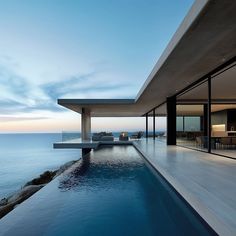 an outdoor swimming pool next to the ocean