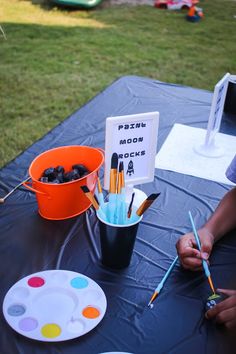 the table is set up with paint brushes and other art supplies for kids to use