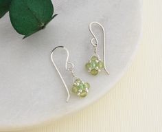 Our peridot earrings feature beautiful green gemstones dangling from handmade sterling silver ear wires, perfect for celebrating an August birthday or your 16th anniversary.  The dainty dangle sways gently as you move adding pop of color and sparkle that will accentuate any outfit.  A symbol of good cheer, the dainty earrings are a meaningful and timeless treat for your jewelry collection.  GEMSTONE SIGNIFICANCE *August birthstone *16th anniversary gemstone *Believed to bring good cheer and health to the wearer HANDMADE WITH LOVE: The cheerful gems are carefully selected, and hand woven into a diamond shape with small silver beads and a sparkling green crystal sits at the center.  The beaded drop is wire wrapped using sterling silver wire to matching handmade ear wires. READY TO GIFT: The Green Drop Earrings For Birthday, Green Sterling Silver Earrings For May Birthstone, Peridot Dangle Earrings Gift, Dainty Green Sterling Silver Earrings, Peridot Earrings For May Birthstone Gift, Peridot Drop Earrings For May Birthstone, Peridot Earrings In Lime Green As A Gift, Green Peridot Earrings For Anniversary, Peridot Lime Green Earrings As Gift